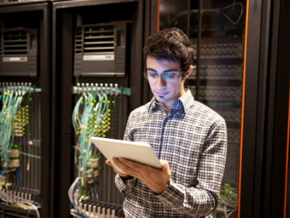 Worker fills out a logbook in an IT server room