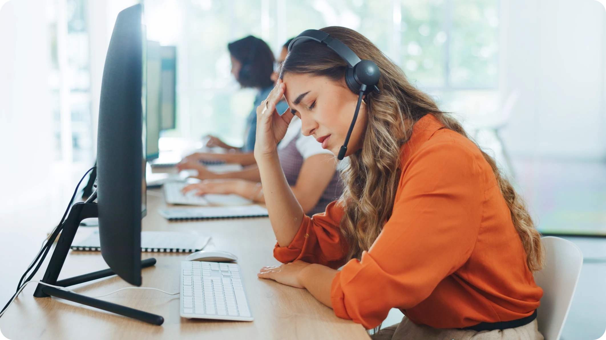 A stressed call center agent feeling the pressure without the help of conversational AI.