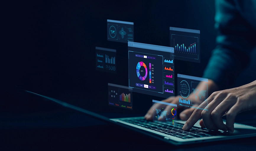 Hologram of laptop screens showing data dashboard with charts and graphs and male hands typing on a laptop.