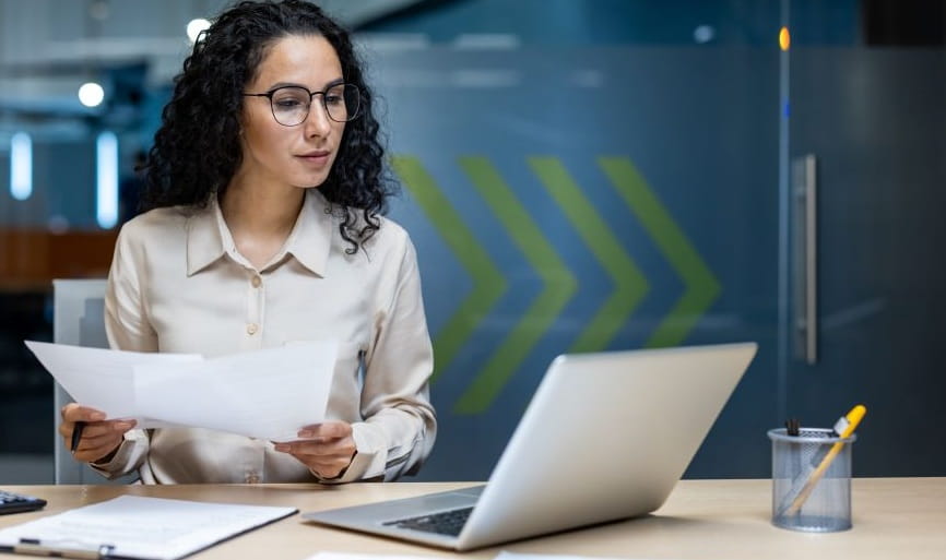 woman with glasses working at laptop