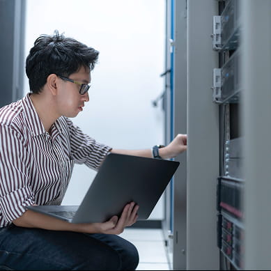 man fixing computer in data center