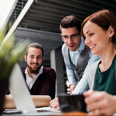 three people looking at laptop