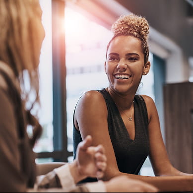 two women at laptop smiling